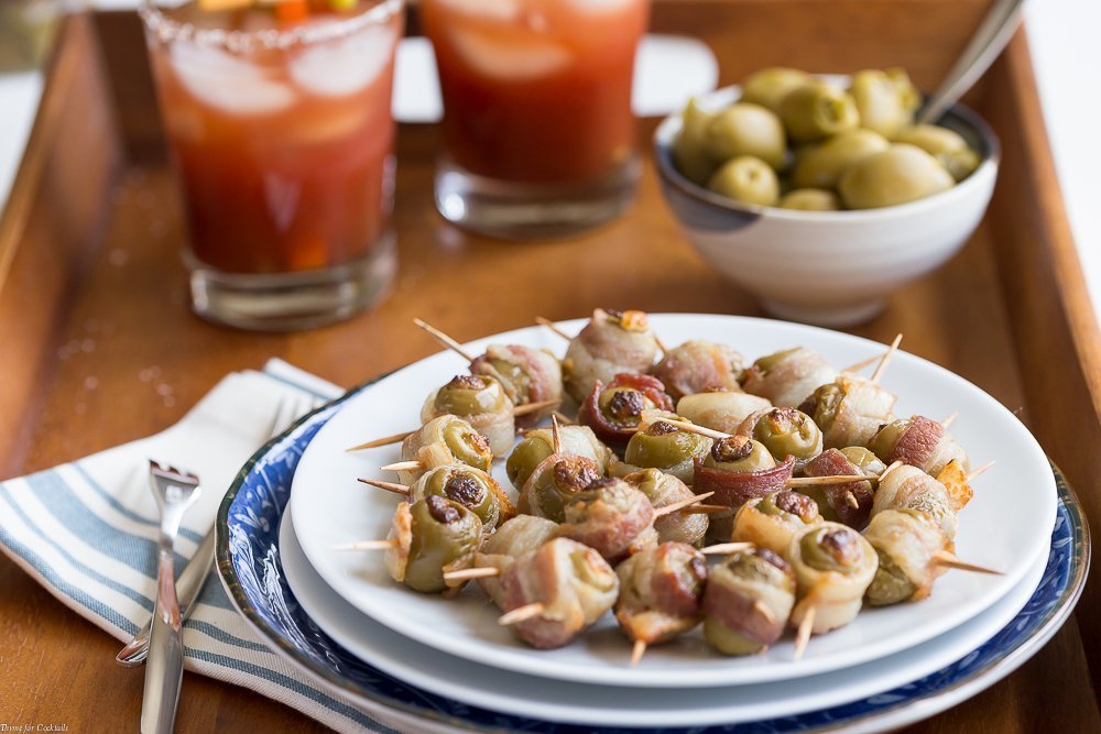 Aceitunas envueltas con tocino picante: aceitunas verdes rellenas con queso crema de jalapeño, luego envueltas en tocino y horneadas hasta que estén crujientes.