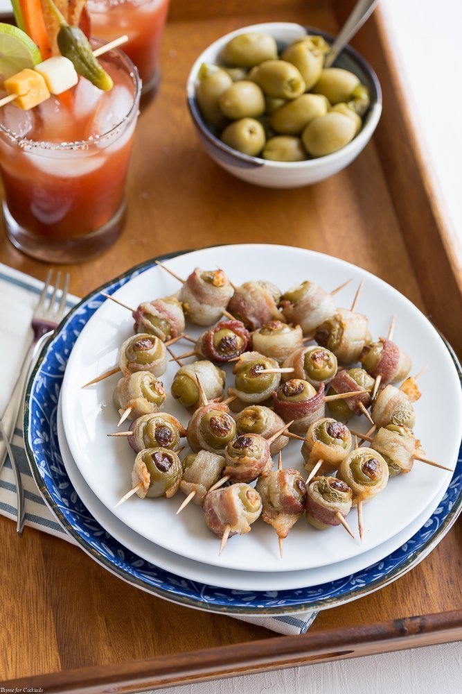 Aceitunas envueltas con tocino picante: aceitunas verdes rellenas con queso crema de jalapeño, luego envueltas en tocino y horneadas hasta que estén crujientes.