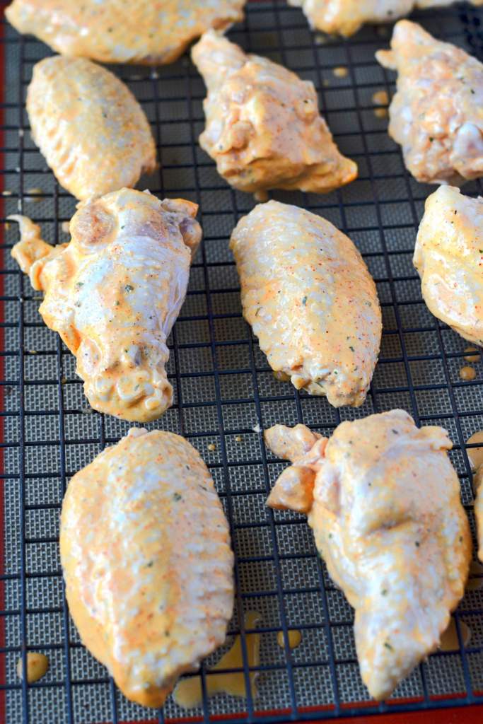 Alitas de pollo picantes del rancho crudas en un estante de cocina