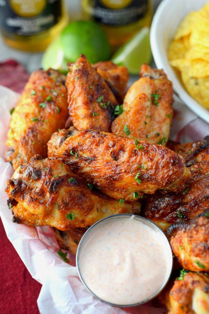 Alitas de pollo picantes de rancho en una canasta con salsa sucia de rancho