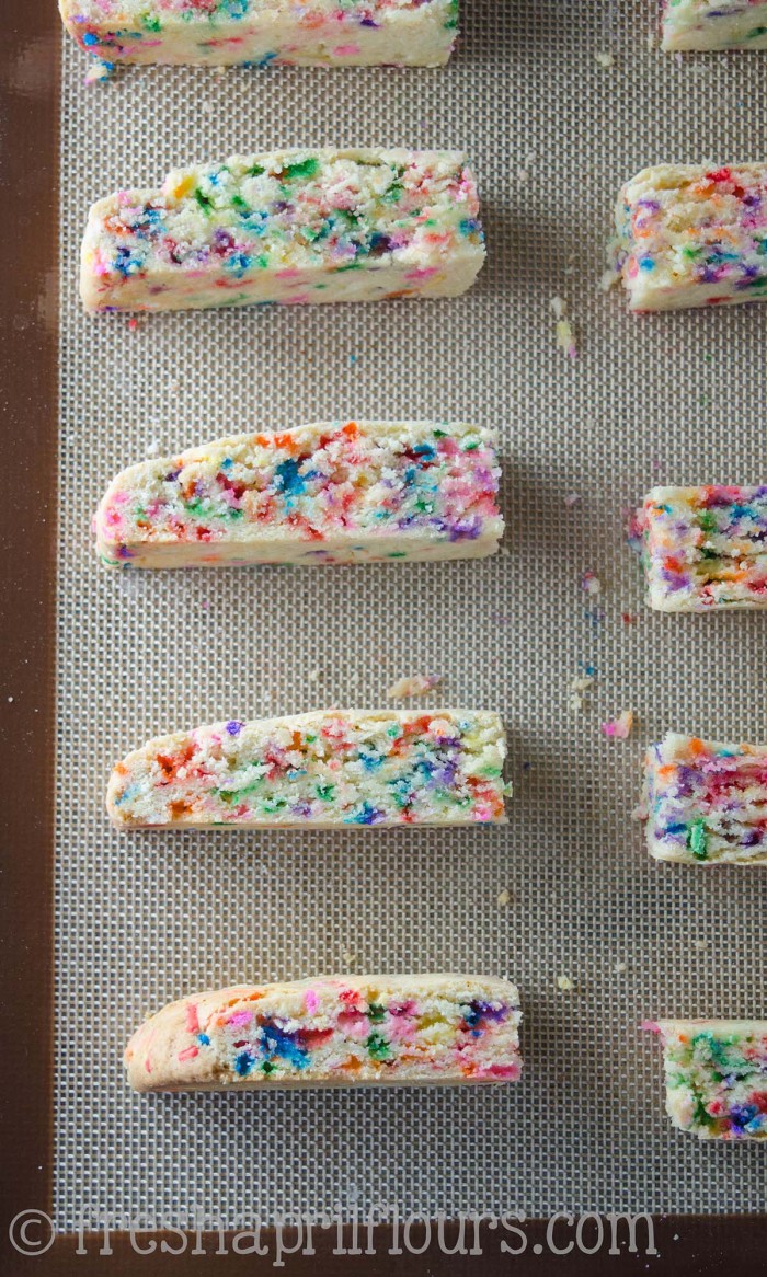 Biscotti Funfetti: Bizcochos crujientes rellenos de chispitas y bañados en chocolate blanco, perfectos para mojar en el café. Una fiesta en tu boca y tu taza!