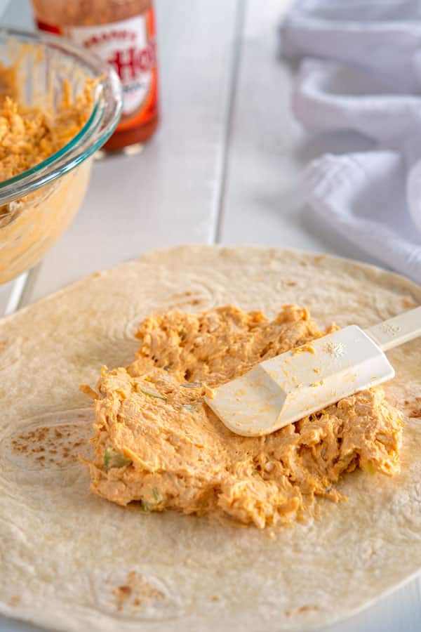 Relleno de rollitos de pollo buffalo que se esparcen sobre tortilla