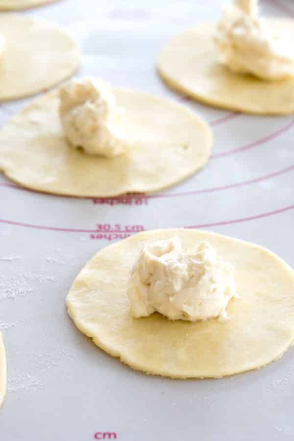 Preparación de pasteles de queso con sopapilla: Mini rondas de corteza de pastel con una cucharada de crema de queso relleno en el centro