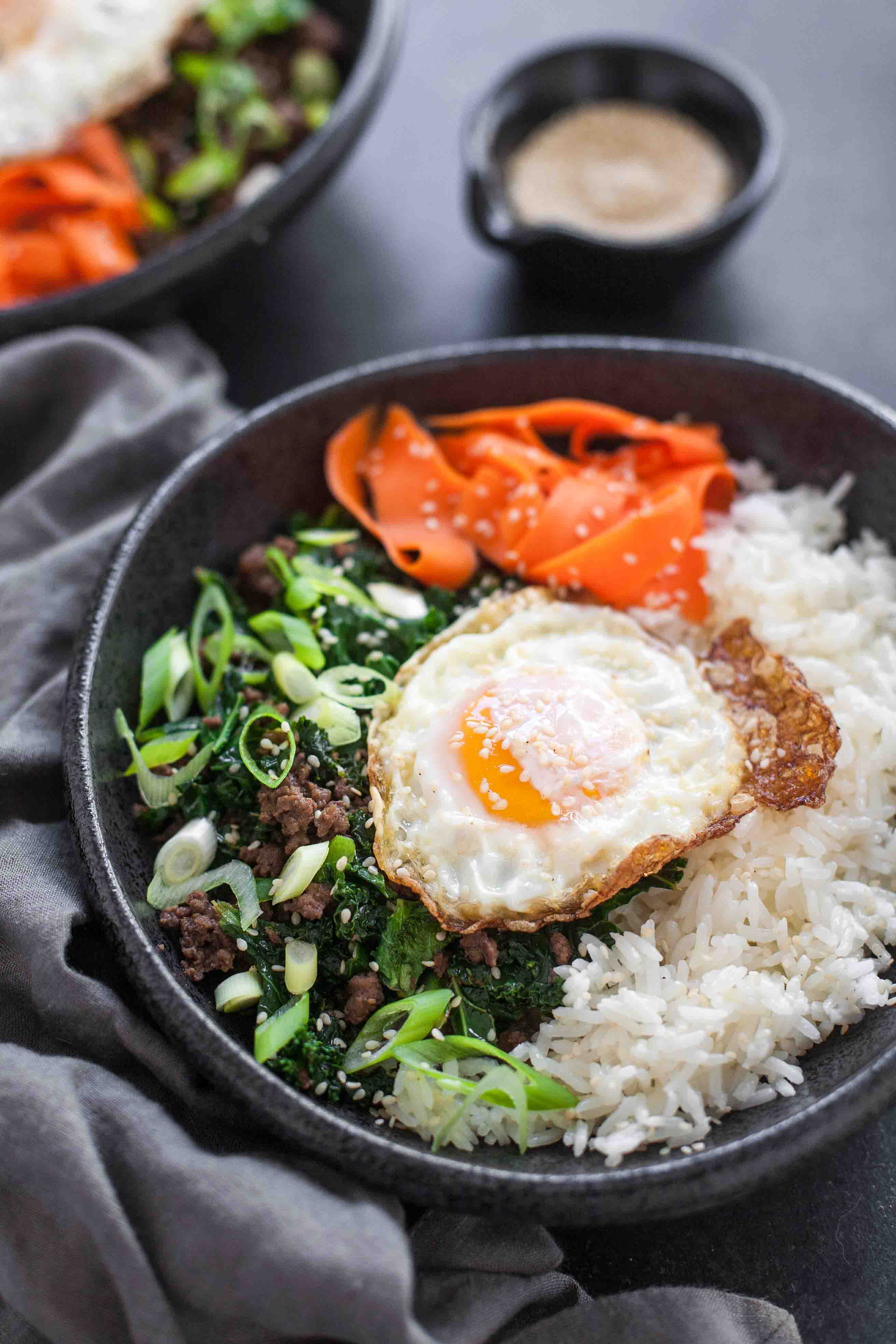 Cuencos de arroz de col y sésamo con huevos fritos y zanahorias en escabeche