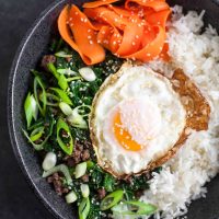 Cuencos de arroz de col y sésamo con huevos fritos y zanahorias en escabeche
