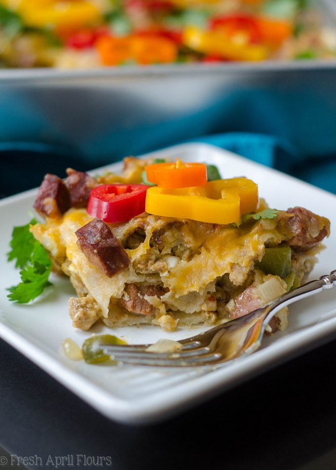Enchilada Breakfast Bake: Huevos revueltos sazonados y verduras combinados con chorizo picante, y en capas entre las tortillas de maíz y la salsa de enchilada para un plato de desayuno fácil y sabroso.