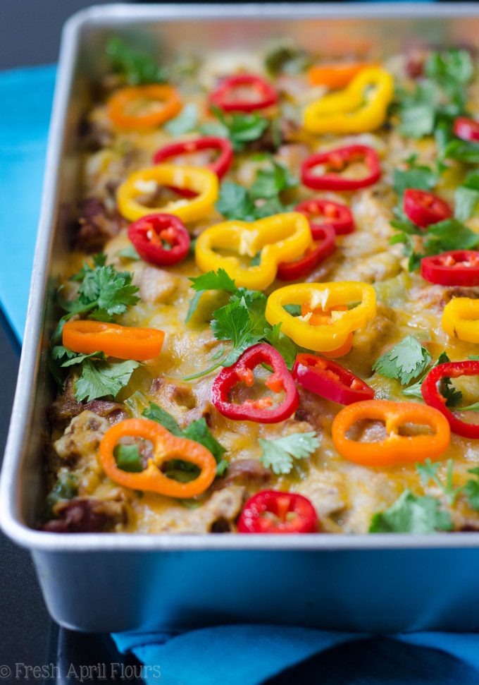 Enchilada Breakfast Bake: Huevos revueltos sazonados y verduras combinados con chorizo picante, y en capas entre las tortillas de maíz y la salsa de enchilada para un plato de desayuno fácil y sabroso.