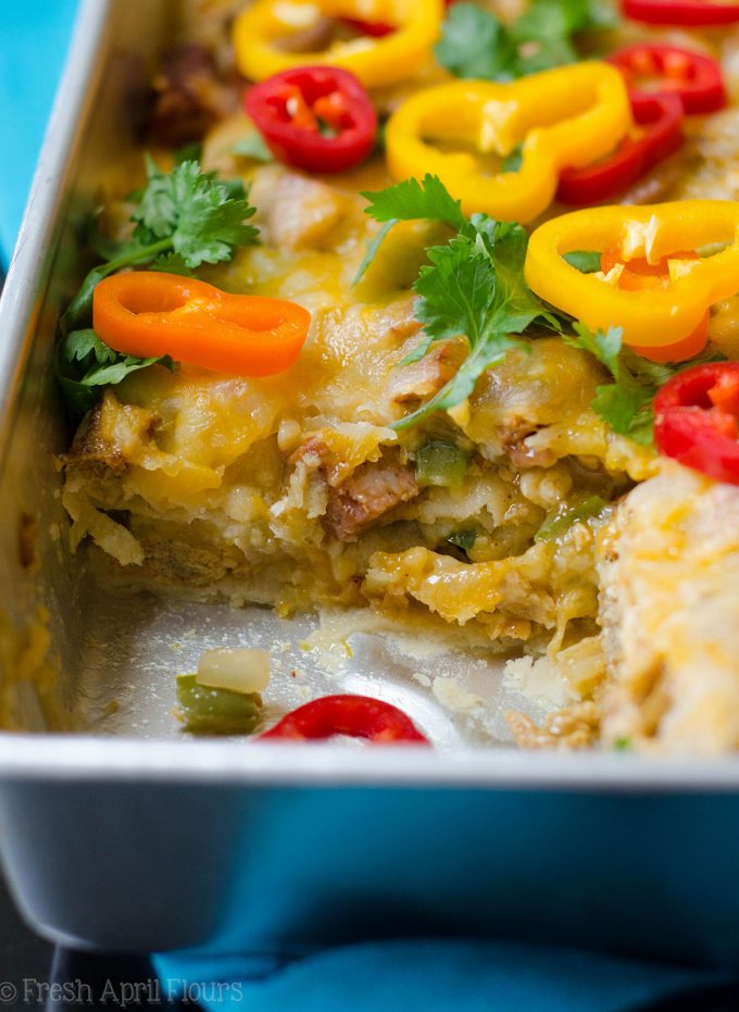 Enchilada Breakfast Bake: Huevos revueltos sazonados y verduras combinados con chorizo picante, y en capas entre las tortillas de maíz y la salsa de enchilada para un plato de desayuno fácil y sabroso.