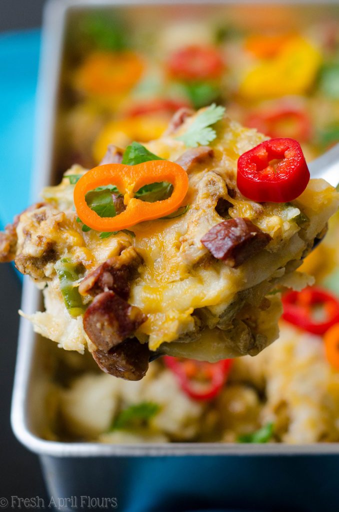 Enchilada Breakfast Bake: Huevos revueltos sazonados y verduras combinados con chorizo picante, y en capas entre las tortillas de maíz y la salsa de enchilada para un plato de desayuno fácil y sabroso.
