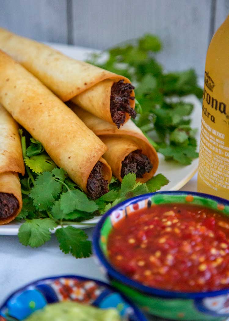 plate of Crispy Beef Flautas near small bowl of salsa