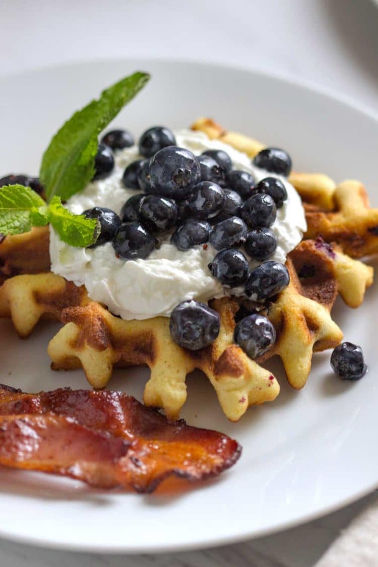 Waffles de arándanos y arándanos frescos y cálidos servidos. Estos gofres tiernos y mantecosos están llenos de bayas frescas, ¡una excelente manera de comenzar su día! Www.keviniscooking.com