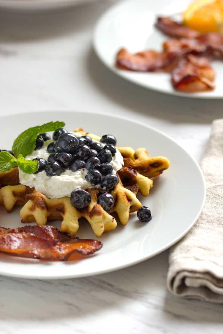 Waffles de arándanos y arándanos frescos y cálidos servidos. Estos gofres tiernos y mantecosos están llenos de bayas frescas, ¡una excelente manera de comenzar su día! Www.keviniscooking.com