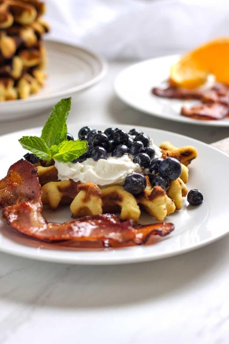 Waffles de arándanos y arándanos frescos y cálidos servidos. Estos gofres tiernos y mantecosos están llenos de bayas frescas, ¡una excelente manera de comenzar su día! Www.keviniscooking.com
