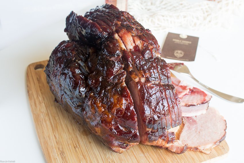 Conviértete en la mejor anfitriona cuando sirvas un Jamón glaseado con Chipotle y Arándanos dulce ahumado esta Pascua; Abrazar el arte de los pequeños lotes, jamón ahumado de madera dura.