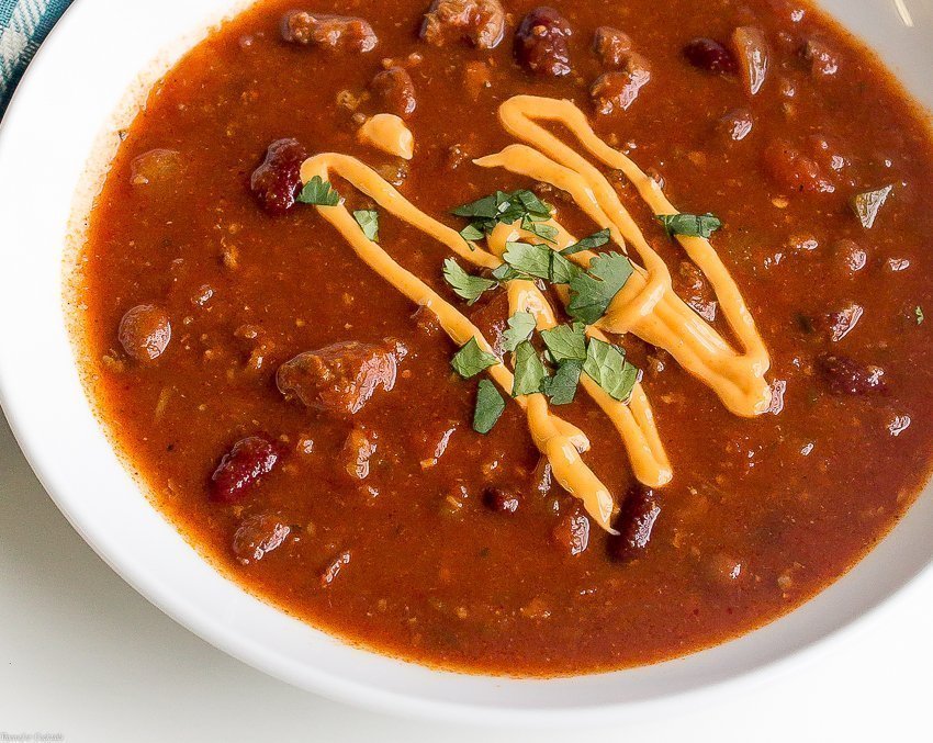Sweet se casa con Smokey en la mejor receta de Chili de Cerdo Dulce con Cerdo Lento que jamás hayas probado. La salchicha de cerdo bourbon dulce hecha localmente agrega una capa única de sabor a este chili de 2 frijoles a base de tomate.