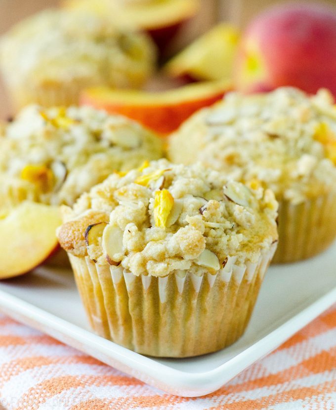 Muffins de Streusel de almendra de melocotón: Muffins de melocotón húmedos y tiernos, acentuados con extracto de almendra y rematados con un streusel de almendra dulce y crujiente.