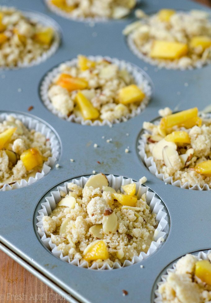 Muffins de Streusel de almendra de melocotón: Muffins de melocotón húmedos y tiernos, acentuados con extracto de almendra y rematados con un streusel de almendra dulce y crujiente.