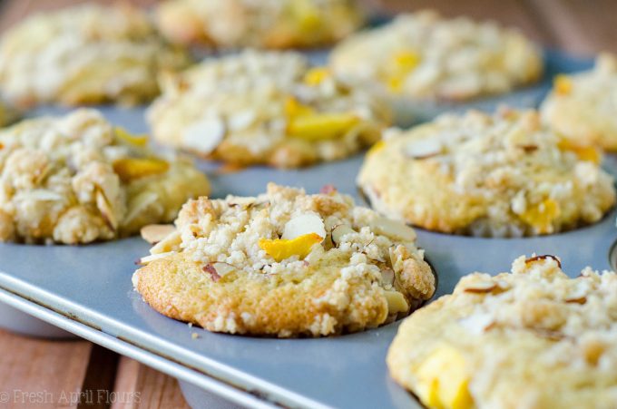 Muffins de Streusel de almendra de melocotón: Muffins de melocotón húmedos y tiernos, acentuados con extracto de almendra y rematados con un streusel de almendra dulce y crujiente.