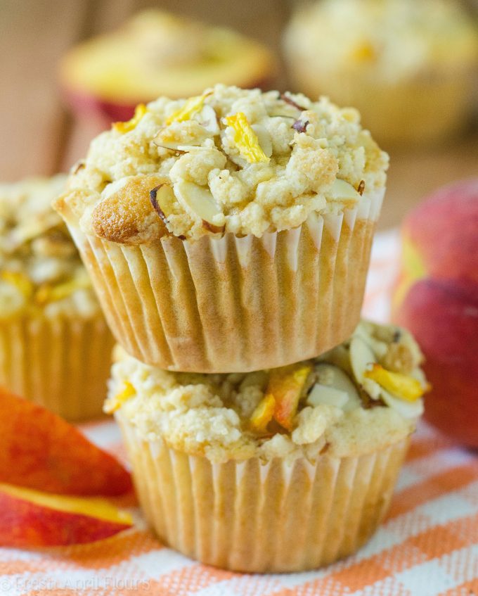 Muffins de Streusel de almendra de melocotón: Muffins de melocotón húmedos y tiernos, acentuados con extracto de almendra y rematados con un streusel de almendra dulce y crujiente.