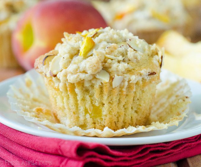 Muffins de Streusel de almendra de melocotón: Muffins de melocotón húmedos y tiernos, acentuados con extracto de almendra y rematados con un streusel de almendra dulce y crujiente.