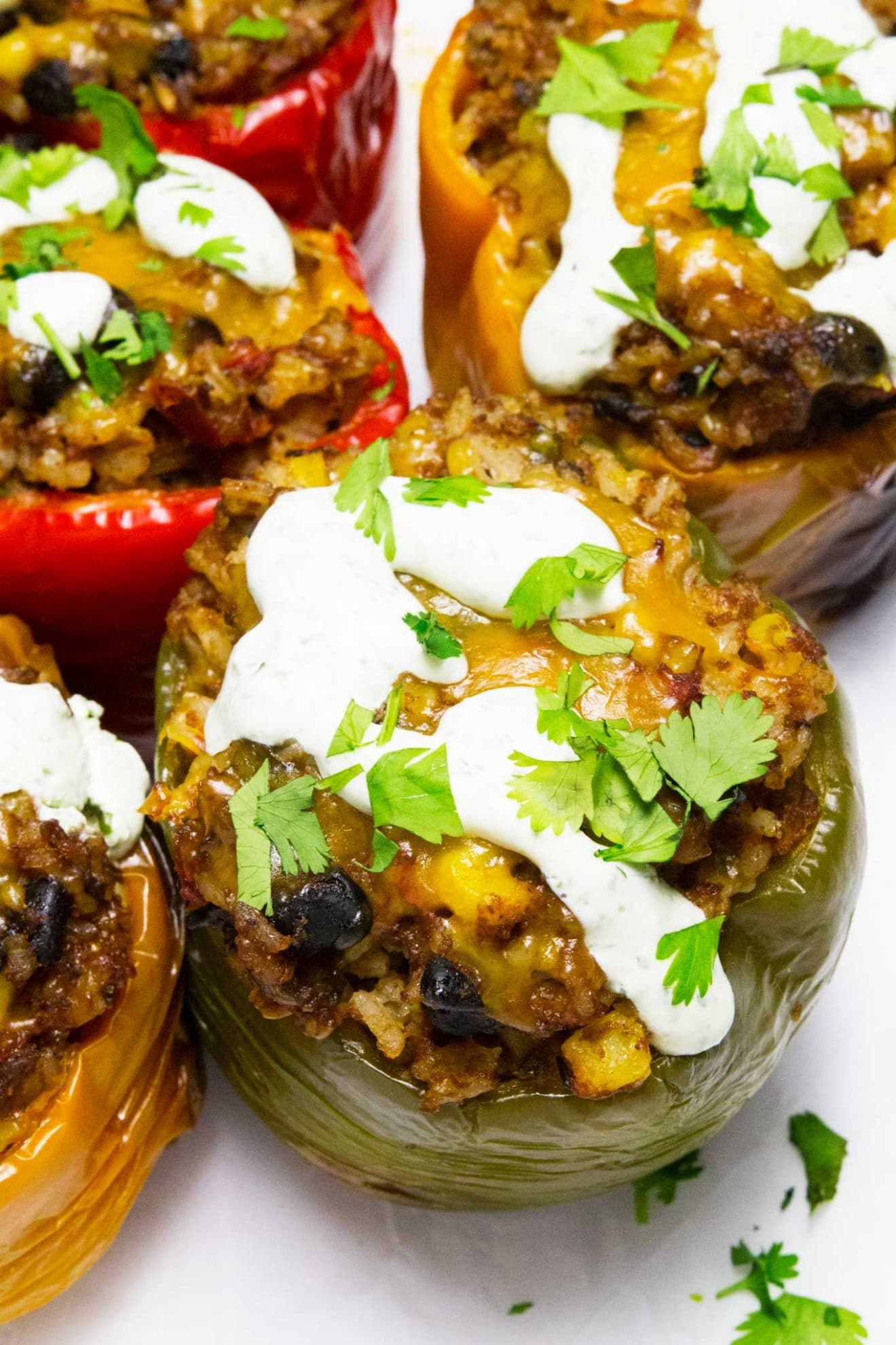 Estos pimientos rellenos de tex-mex de cocción lenta le dan un pequeño giro a la receta original de pimientos rellenos. ¡Se hacen en la olla de cocción lenta y se cubren con una increíble crema agria de cilantro para completar esta deliciosa y fácil comida!