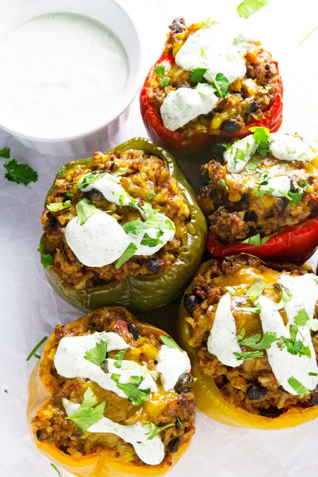 Estos pimientos rellenos de tex-mex de cocción lenta le dan un pequeño giro a la receta original de pimientos rellenos. ¡Se hacen en la olla de cocción lenta y se cubren con una increíble crema agria de cilantro para completar esta deliciosa y fácil comida!