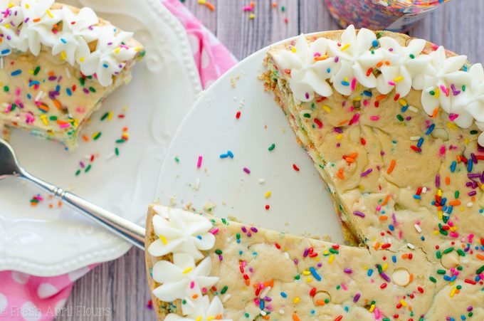 Funfetti Sugar Cookie Cake: Suave y mantecosa en el centro, crujiente alrededor de los bordes y llena de un montón de trocitos de chocolate blanco y confites para celebrar cualquier ocasión. Rematado con una crema de mantequilla de vainilla de almendra cremosa y mantecosa.