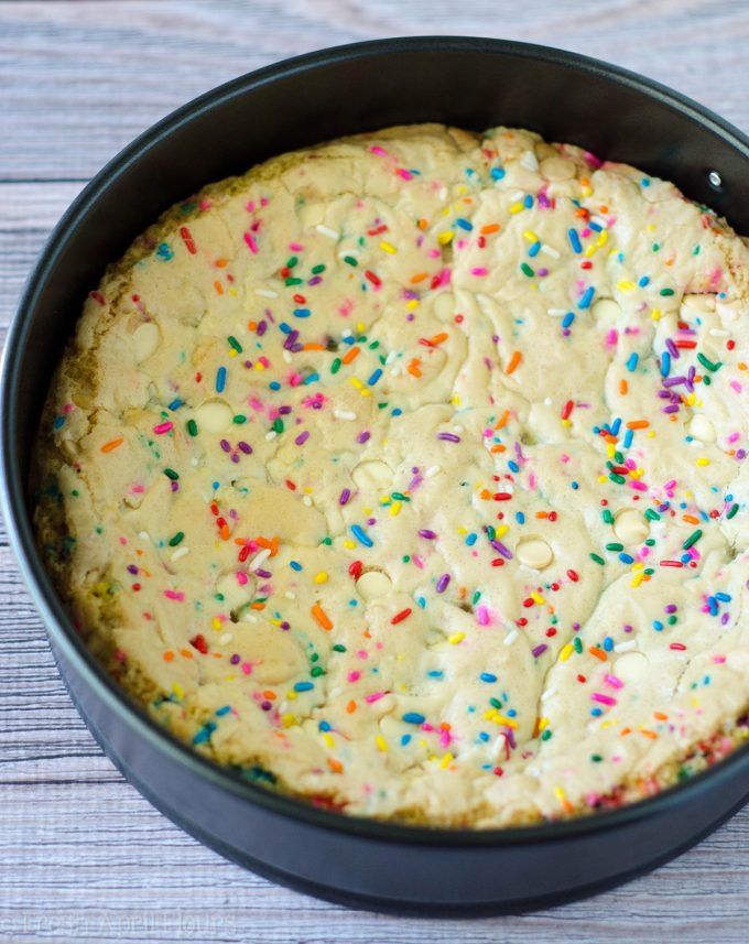 Funfetti Sugar Cookie Cake: Suave y mantecosa en el centro, crujiente alrededor de los bordes y llena de un montón de trocitos de chocolate blanco y confites para celebrar cualquier ocasión. Rematado con una crema de mantequilla de vainilla de almendra cremosa y mantecosa.