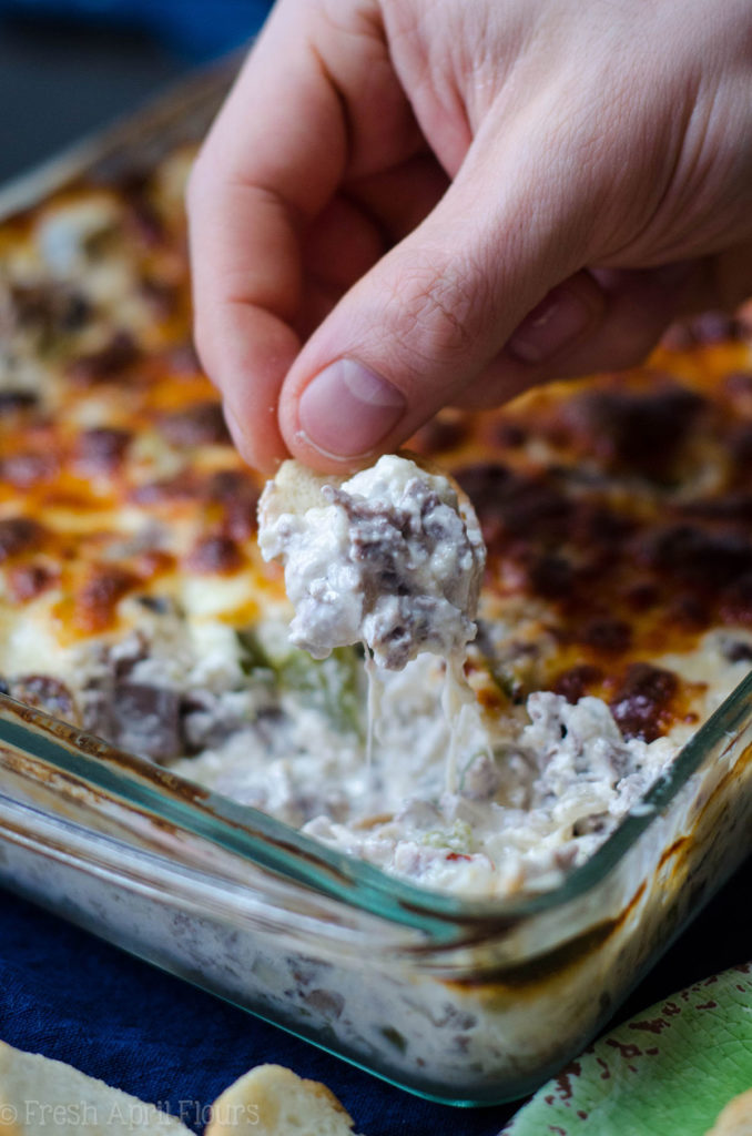 Philly Cheesesteak Dip: salsa cremosa rellena con sabrosas cebollas, pimiento verde, champiñones y carne asada, cubierta con una capa crujiente de queso provolone.
