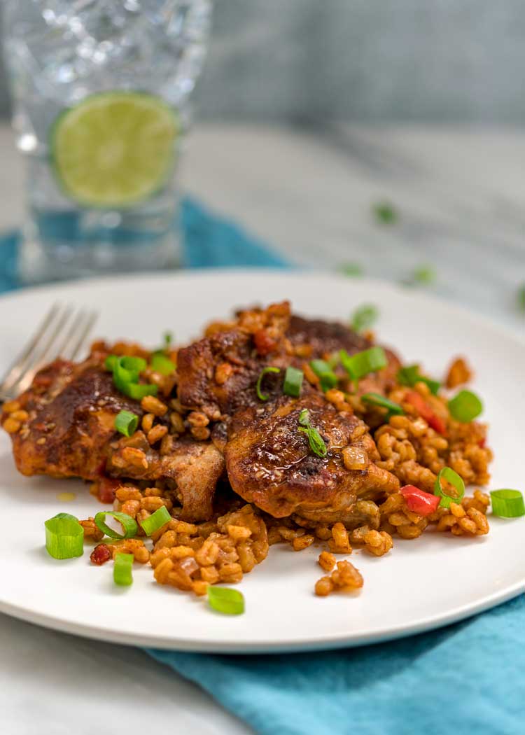 Smothered Chicken and Barley on white plate with glass of ice water
