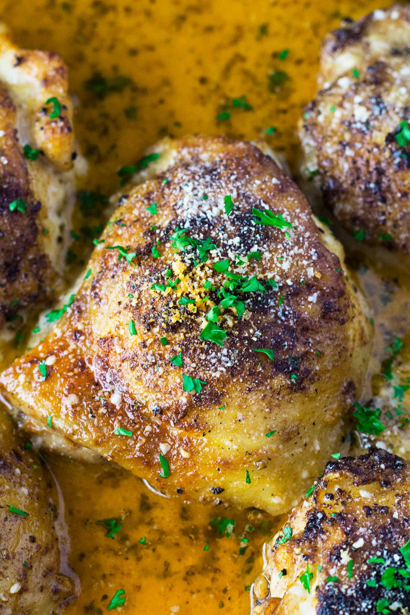 Muslos de pollo con mantequilla de limón, chamuscados a la perfección y terminados en el horno en una buena salsa de crema parmesana de ajo que se lame los dedos.