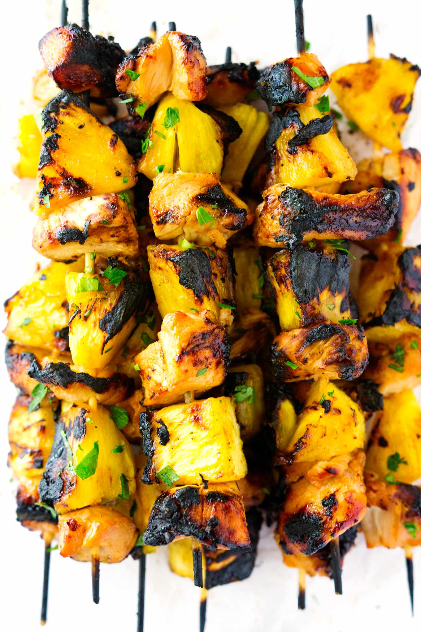 Estas brochetas de pollo y piña hawaianas llevan el pollo y la piña al siguiente nivel. La marinada hawaiana en el pollo y el azúcar moreno en la piña a la parrilla son una manera segura de hacer una deliciosa comida en menos de 10 minutos de cocción. 