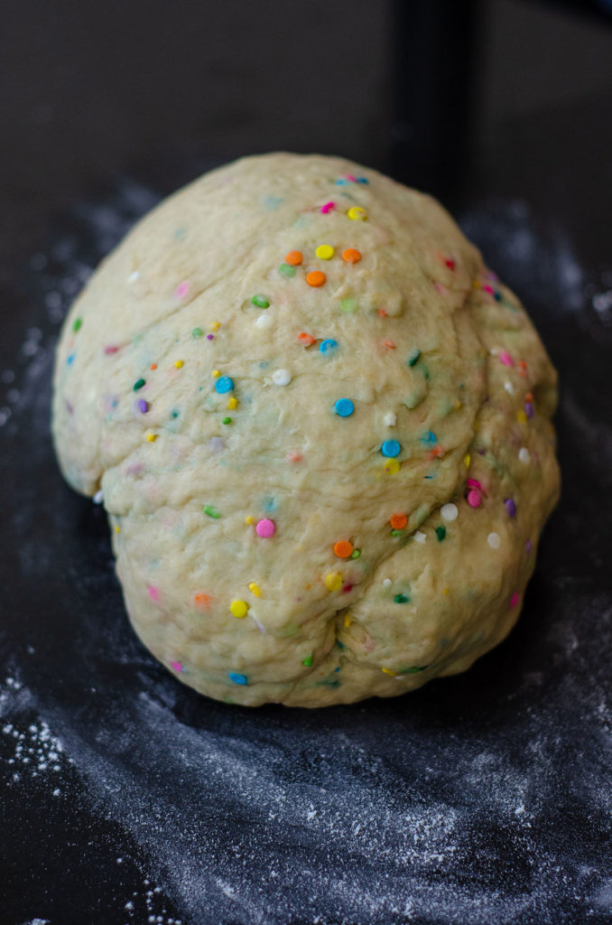 Rollos de canela Funfetti: rollos de levadura simples rellenos con canela dulce y pegajosa y salpicados con chispas. ¡Difunde con un glaseado de queso crema fácil para un desayuno o un placer indulgente!