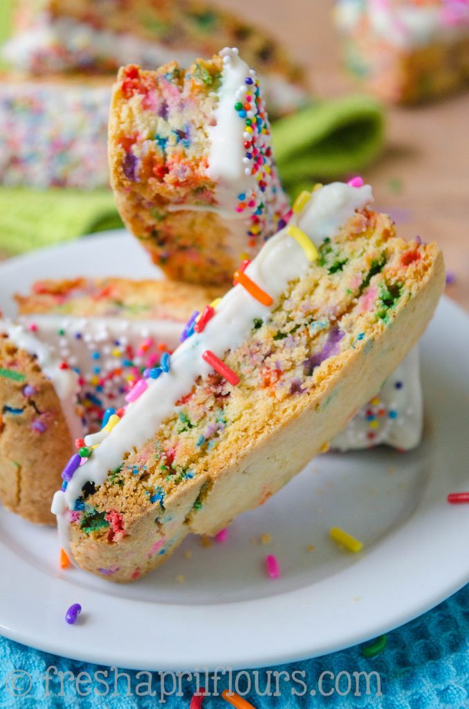 Biscotti Funfetti: Bizcochos crujientes rellenos de chispitas y bañados en chocolate blanco, perfectos para mojar en el café. Una fiesta en tu boca y tu taza!