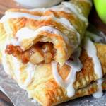 empanadas de manzana con glaseado de glaseado encima y una taza de café blanco y una manzana verde