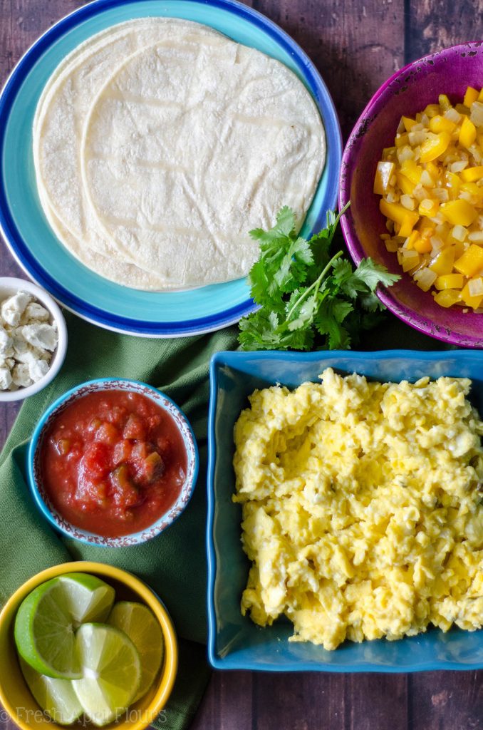Tacos vegetarianos para el desayuno: mezcle y combine sus ingredientes favoritos con la base de cremosos huevos revueltos con queso de cabra y pimientos y cebollas sazonados. Perfecto para un desayuno buffet para complacer a una multitud.