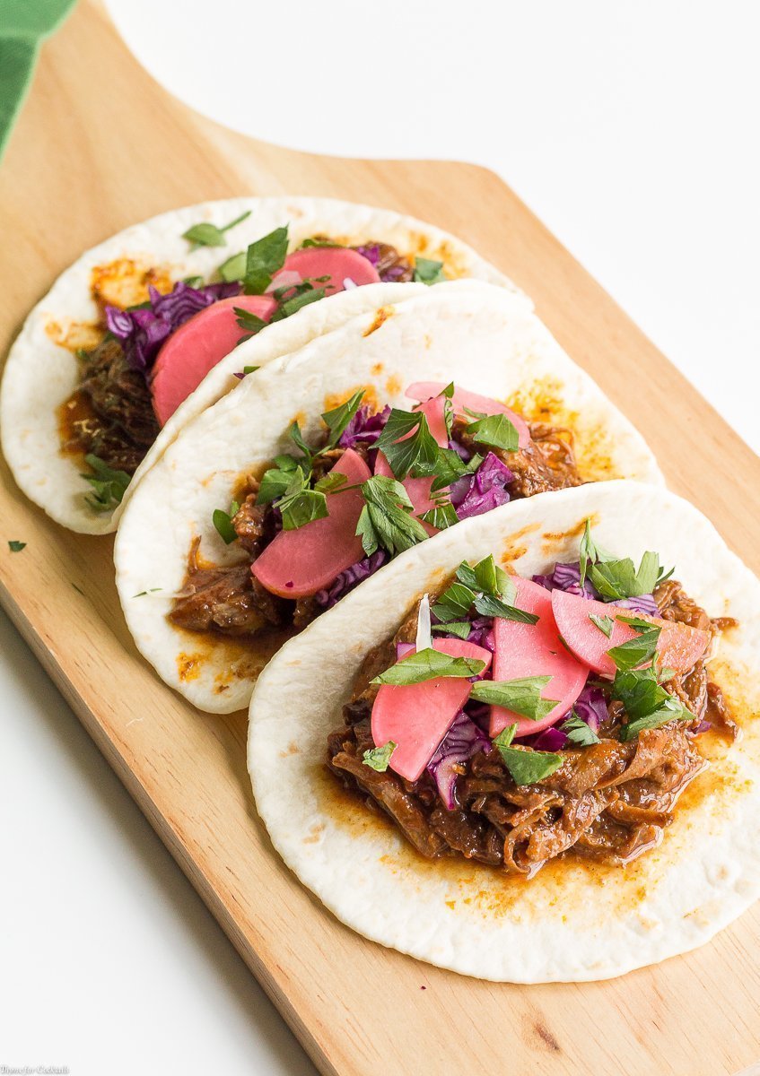 Taco Tuesday no tiene que ser difícil cuando preparas estos Tacos de Mole de Cerdo Lento de Olla de Cocción Lenta para la cena de esta semana. Cubra con rábanos en escabeche para un crujiente picante.