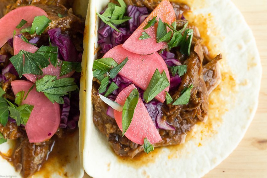 Taco Tuesday no tiene que ser difícil cuando preparas estos Tacos de Mole de Cerdo Lento de Olla de Cocción Lenta para la cena de esta semana. Cubra con rábanos en escabeche para un crujiente picante.