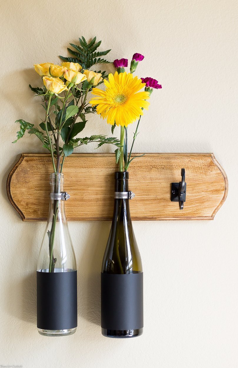 Si está buscando una forma creativa de reciclar sus botellas de vino de fin de semana, ¡no busque más! Este tutorial de jarrón de pared de botellas de vino de bricolaje es justo lo que necesita.